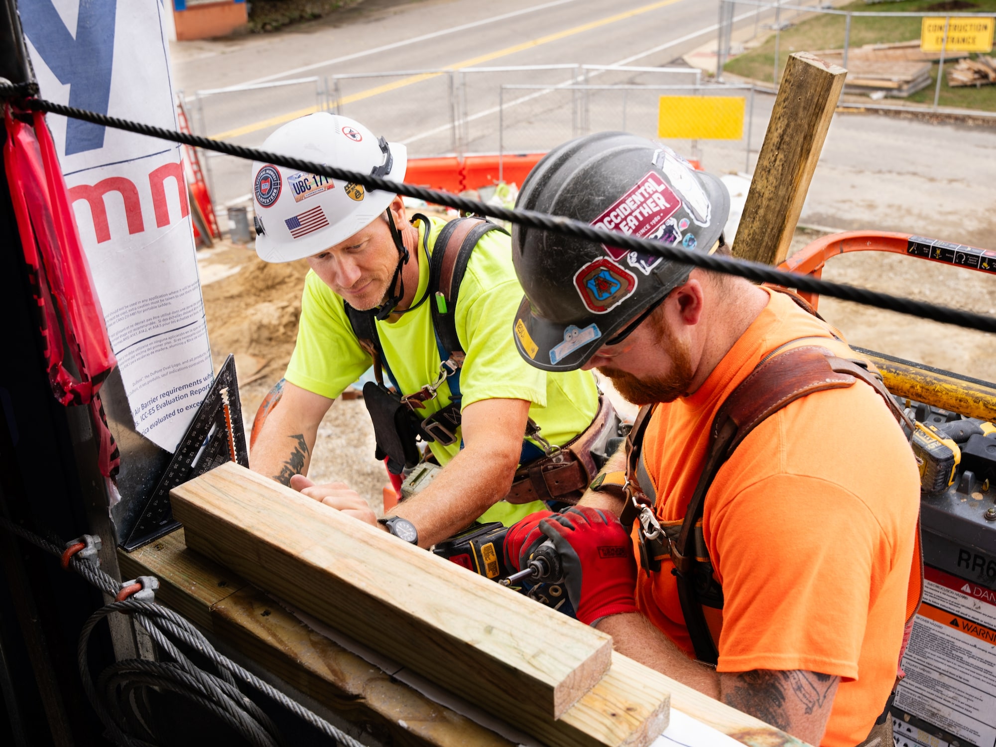 Two construction workers collaborating on framing